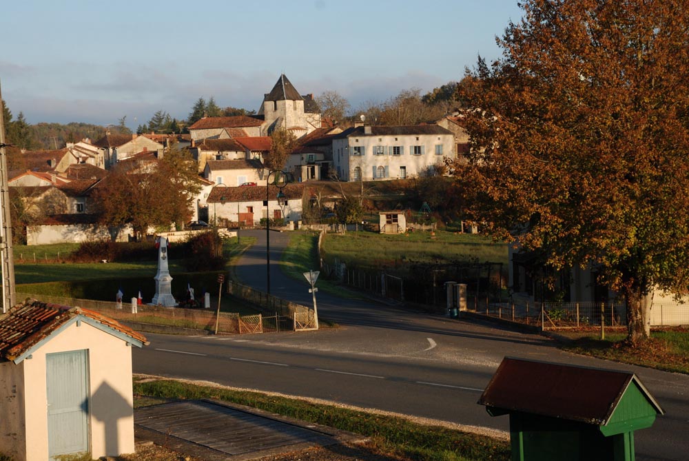 Village pittoresque avec église et arbres automnaux.