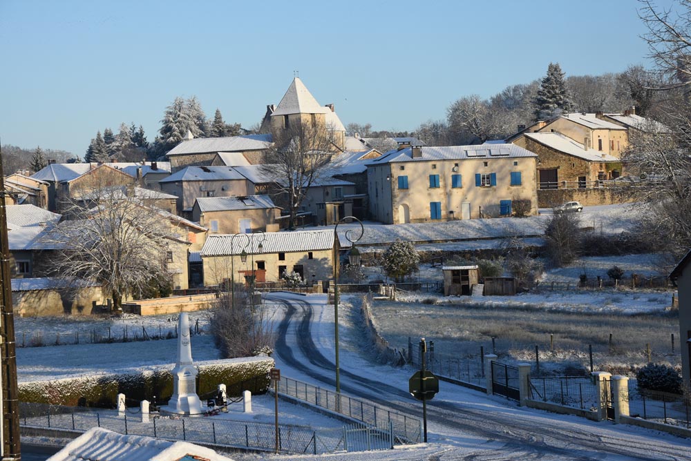 Village enneigé avec église et maisons.