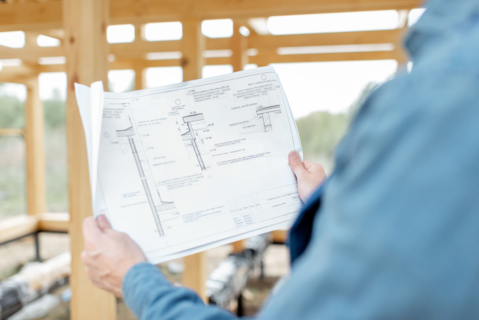 Personne tenant un plan de construction.