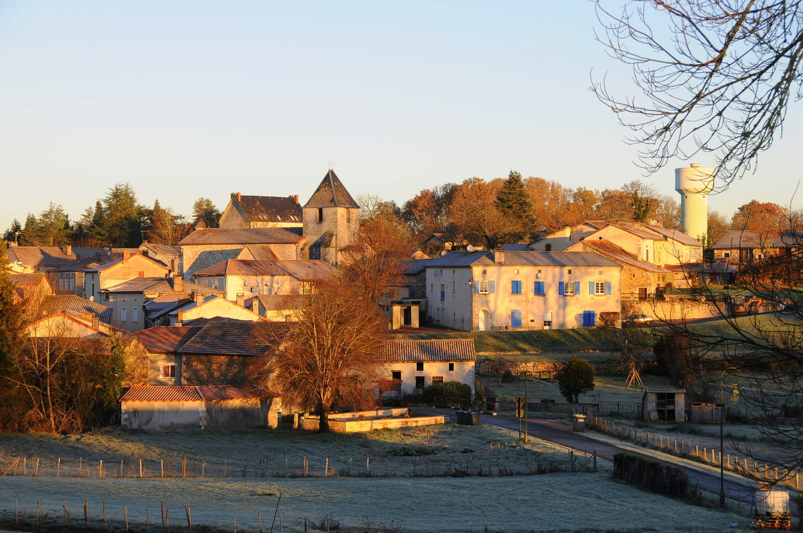 Village français au lever du soleil, bâtiments en pierre.